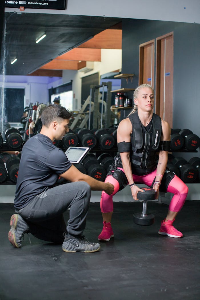 services-03 Woman in a personal training session using weights indoors, showcasing strength and fitness.